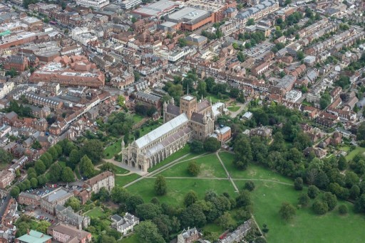 Aerial view on a cloudy day of St Albans Cathedral, a beautiful piece of architecture dating back to the Norman period, with it's surrounding park and traditional residential streets