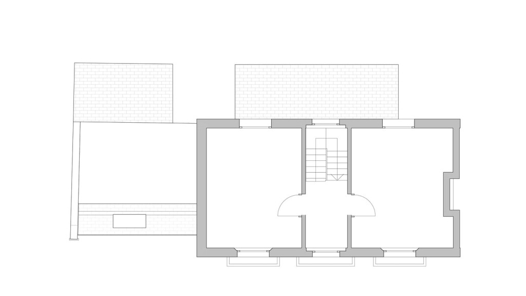 Architectural blueprint of an existing first-floor layout with clean lines and minimal detail, highlighting the structure's walls and openings, including the precise location of the staircase for a residential building.