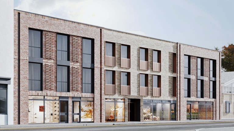 Contemporary mixed-use building facade featuring new-build flats above street-level retail spaces, with a modern architectural design incorporating red brick textures, vertical accents, large windows, and creative use of patterns, contributing to a revitalised and stylish urban streetscape.